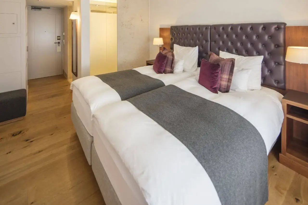 Gemütliches Hotelzimmer mit großem Doppelbett, stilvoller Einrichtung und warmen Farben.