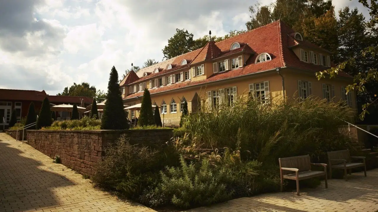 Eine stilvolle Hotelaußenansicht mit idyllischer Lage im Grünen.