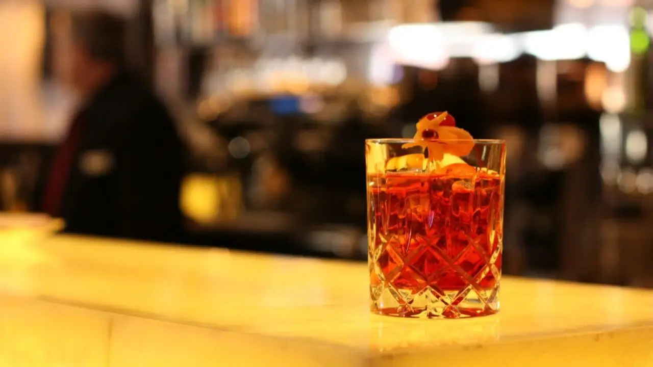Eine stimmungsvolle Bar-Szene in einem Restaurant mit Terrasse Stuttgart, edler Cocktail im Fokus.