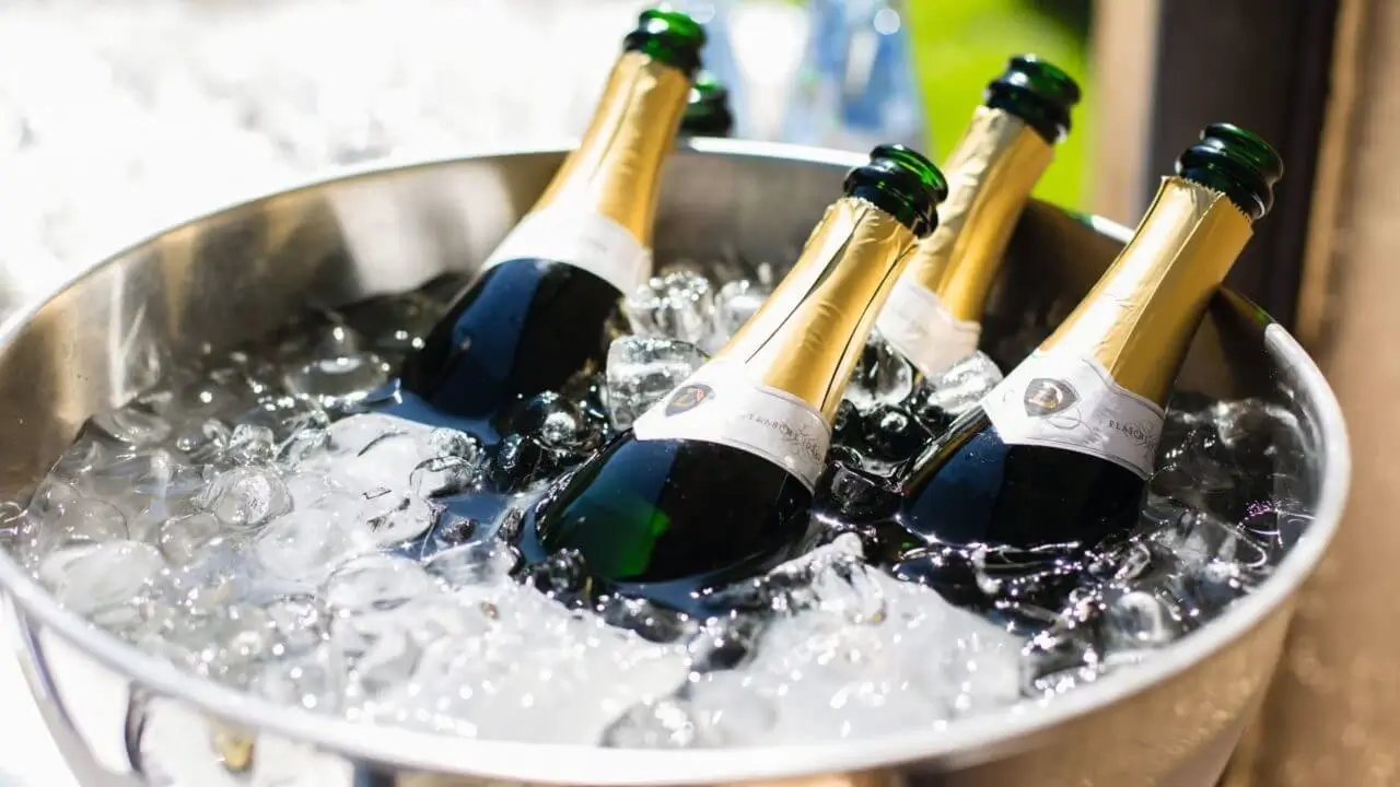 Vier Champagnerflaschen liegen in einem Kübel mit Eis.