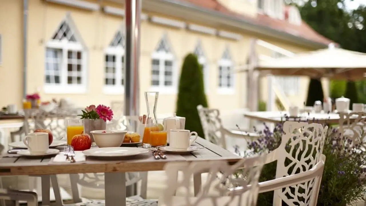 Ein Frühstück auf der idyllischen Hotelterrasse mit frischen Säften und Gebäck.