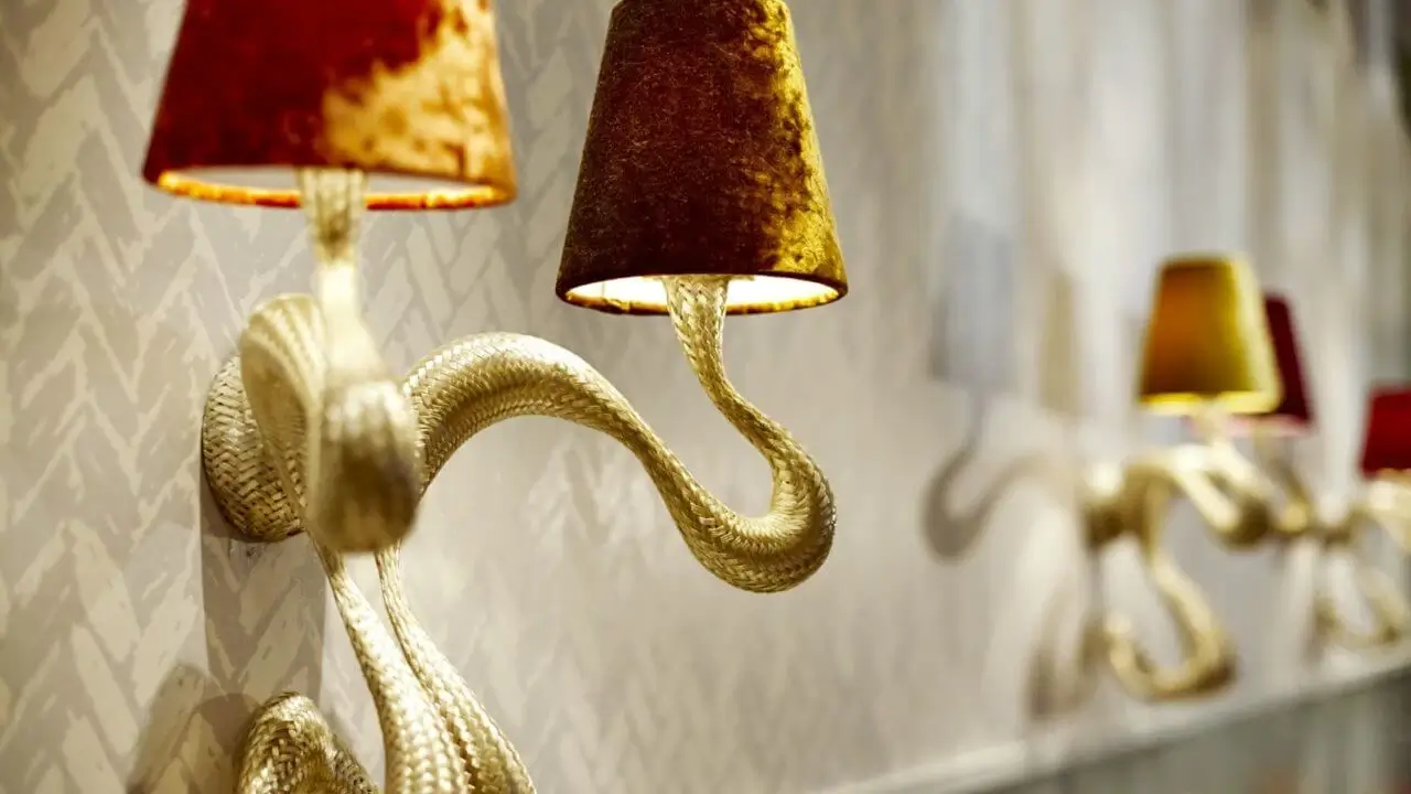 Elegante Wandleuchten in Schlangenform mit edlen Stofflampenschirmen.
