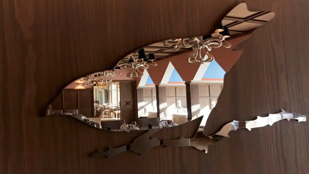 Blick durch eine Holzschnitzerei ins stilvolle gourmet restaurant stuttgart mit eleganter Einrichtung.