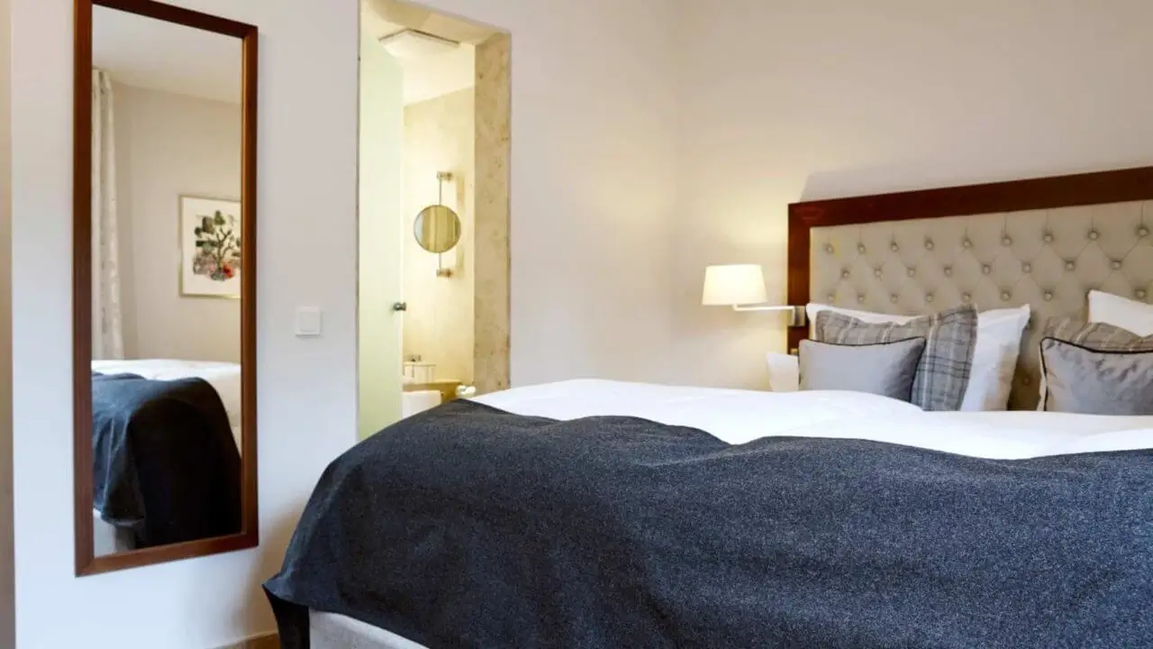 Modernes Standard-Doppelzimmer mit Doppelbett, Schreibtisch und Blick auf grüne Umgebung.